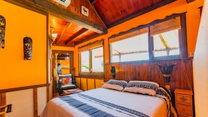A room with a wooden ceiling, a bed with patterned bedding, a nightstand, and a window with a view of the outside. - Cubo's Mijas Finca Huerta Rica Sabana / shared pool / views (Mijas Pueblo)