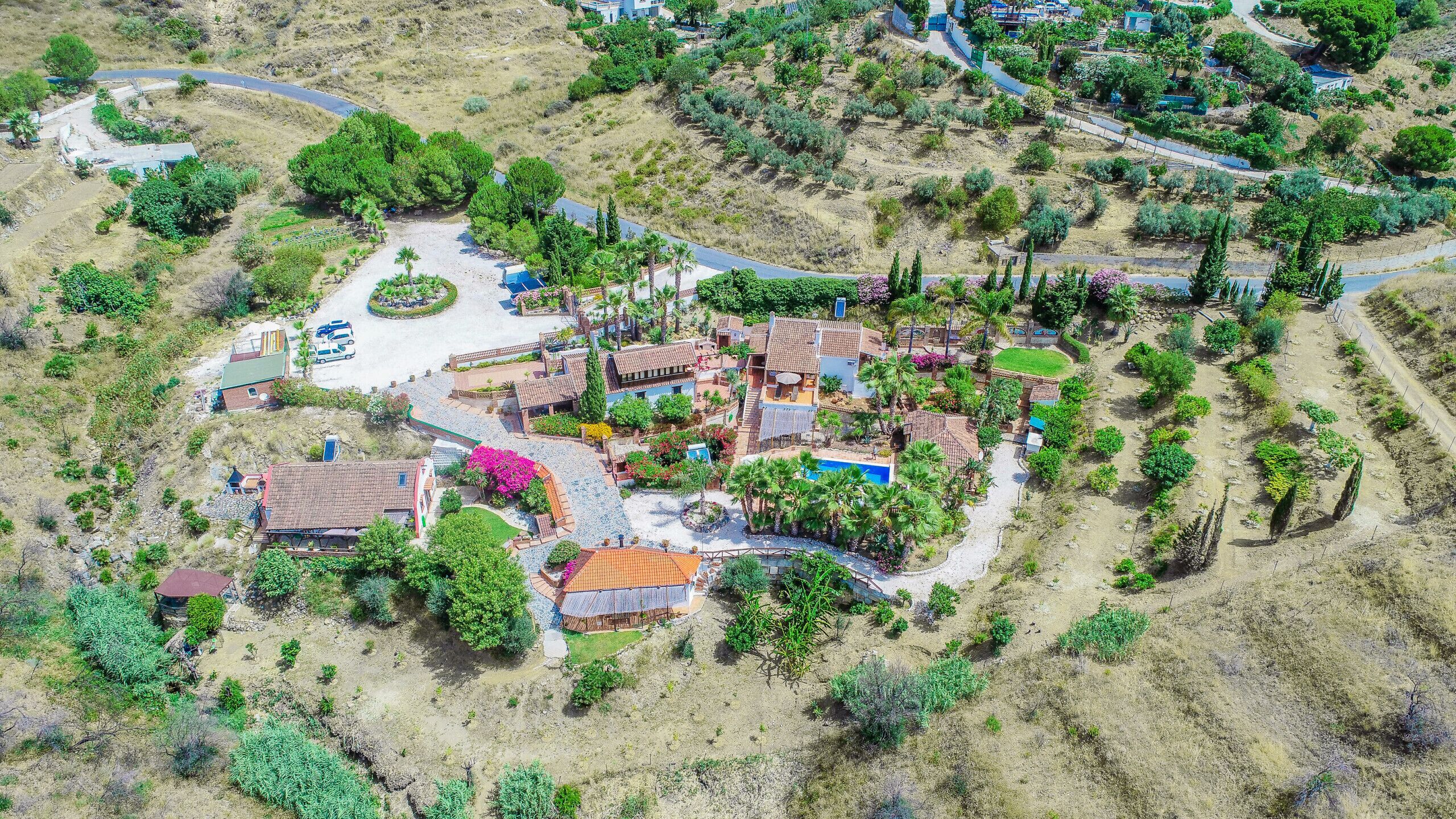 Zona residencial con varias casas, una piscina y una calle.