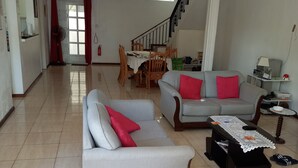 Una sala de estar amplia con dos sofás, una mesa de centro y un comedor con mesa y sillas.