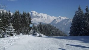 A snowy mountain road with a sign indicating a 19 km distance.