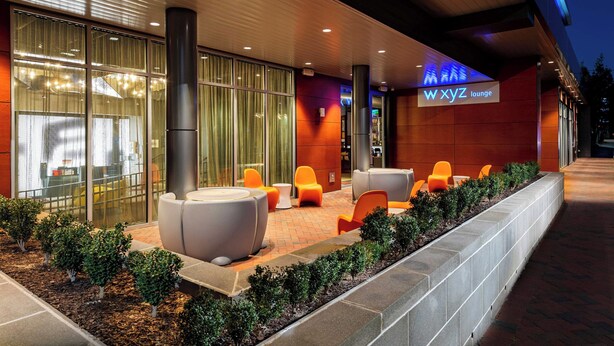 A modern lounge area with seating and a sign for 'WXYZ lounge'. - Aloft by Marriott Savannah Downtown Historic District (Savannah)