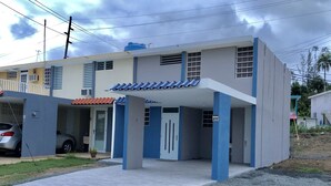 Uma casa moderna de dois andares com entrada coberta e um carro estacionado na entrada.