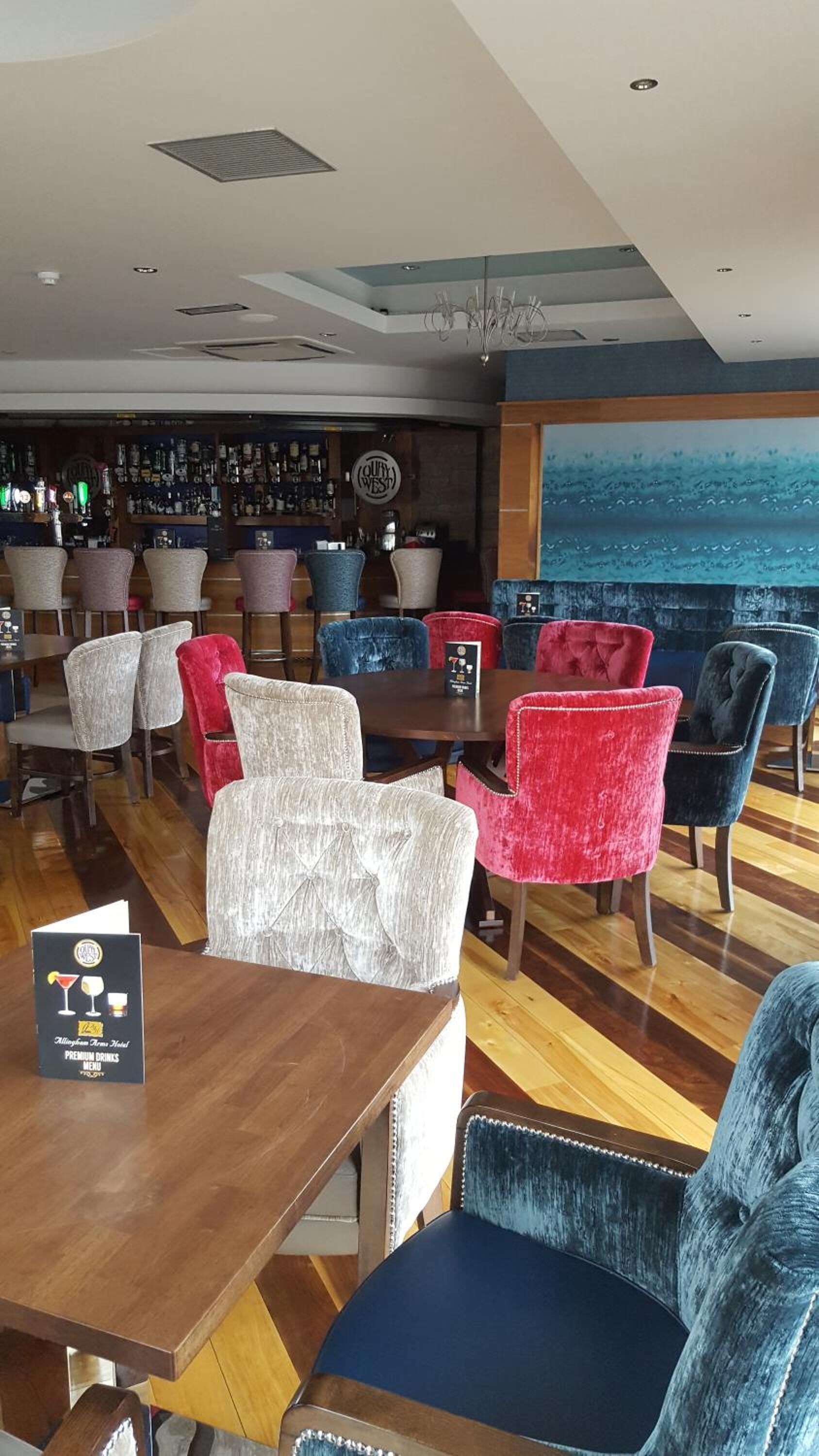 A bar area with a variety of seating options, including chairs and a table with a menu.