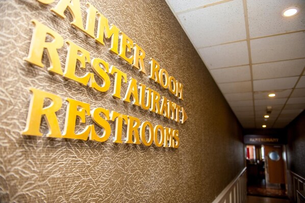 A sign for the 'AMER ROOM RESTAURANT RESTROOMS' in a hotel corridor. - Allingham Arms Hotel (Bundoran)