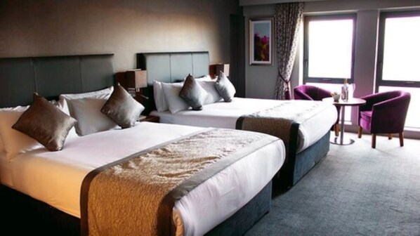 A hotel room with two beds, a small table, and a chair. - Allingham Arms Hotel (Bundoran)