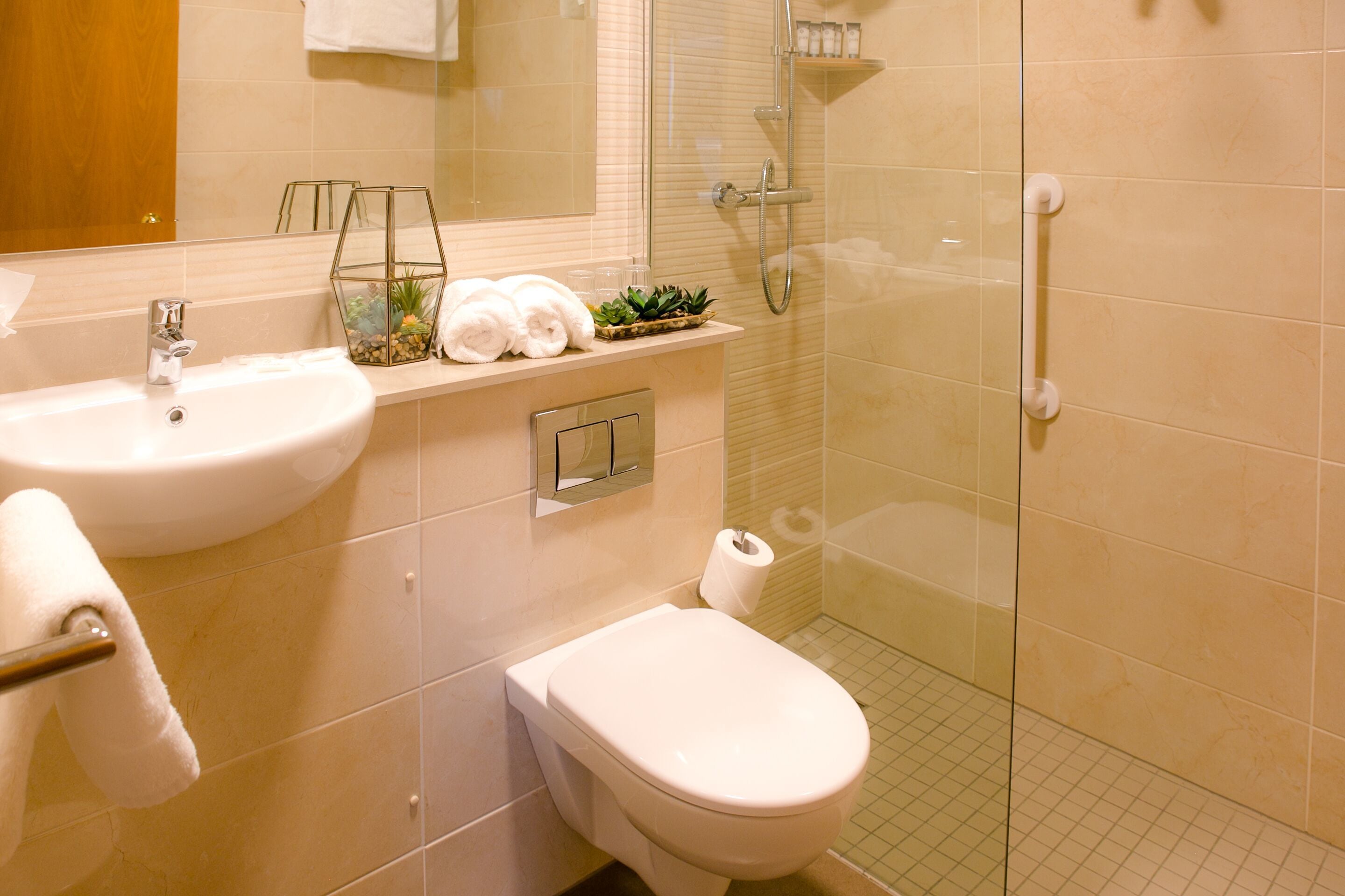 A modern bathroom with a sink, toilet, and glass-enclosed shower.