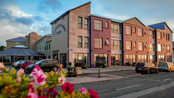 Un hotel de varios pisos con un letrero que dice "ALLINGHAM ARMS HOTEL".