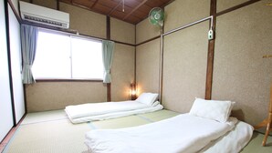 A room with two beds, an air conditioner, a standing fan, and a window with curtains. - Osaka 2 story-house, Namba 10mins by bus (Ōsaka-shi)