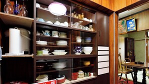 A wooden cabinet with shelves containing various dishes and glassware. - Osaka 2 story-house, Namba 10mins by bus (Ōsaka-shi)