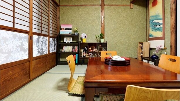 A traditional Japanese room with tatami flooring, a low wooden table, and a bookshelf with various items. - Osaka 2 story-house, Namba 10mins by bus (Ōsaka-shi)