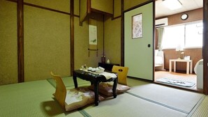 A traditional Japanese room with tatami flooring, a low table with a cushion, and a sliding door leading to another room. - Osaka 2 story-house, Namba 10mins by bus (Ōsaka-shi)