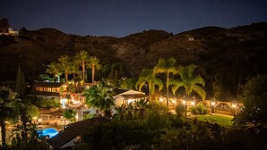 A resort with multiple buildings, a swimming pool, and palm trees.