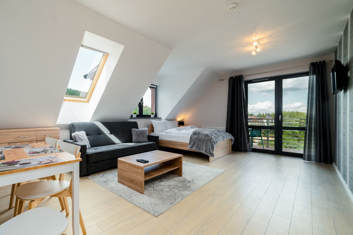 Un loft moderno con comedor, sofá, cama y balcón con vistas.