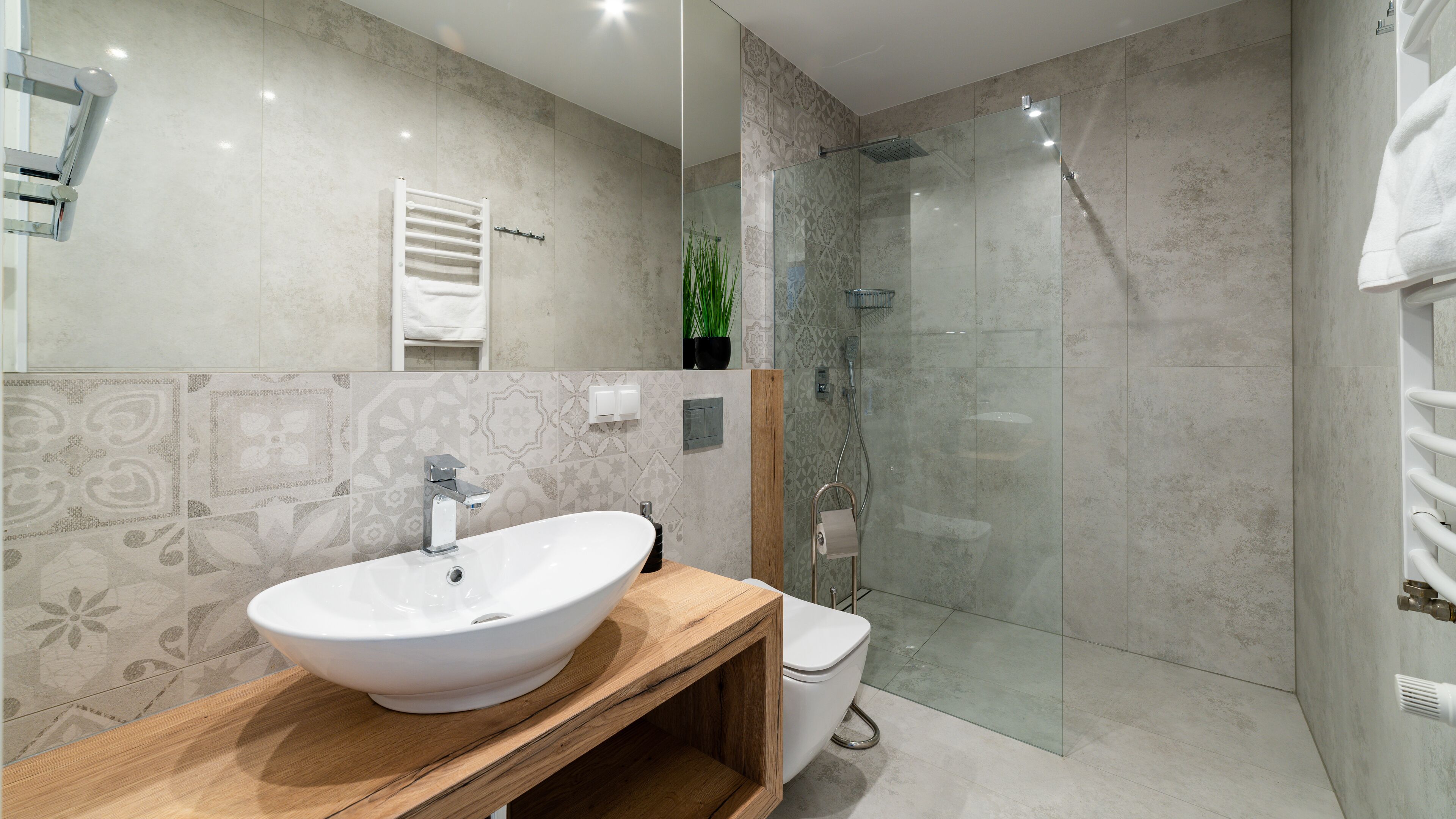 A modern bathroom with a freestanding sink, a toilet, and a glass-enclosed shower.