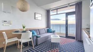 A modern hotel room with a balcony, a dining area, and a kitchen. - Sun & Snow Triventi Mountain Residence (Karpacz)