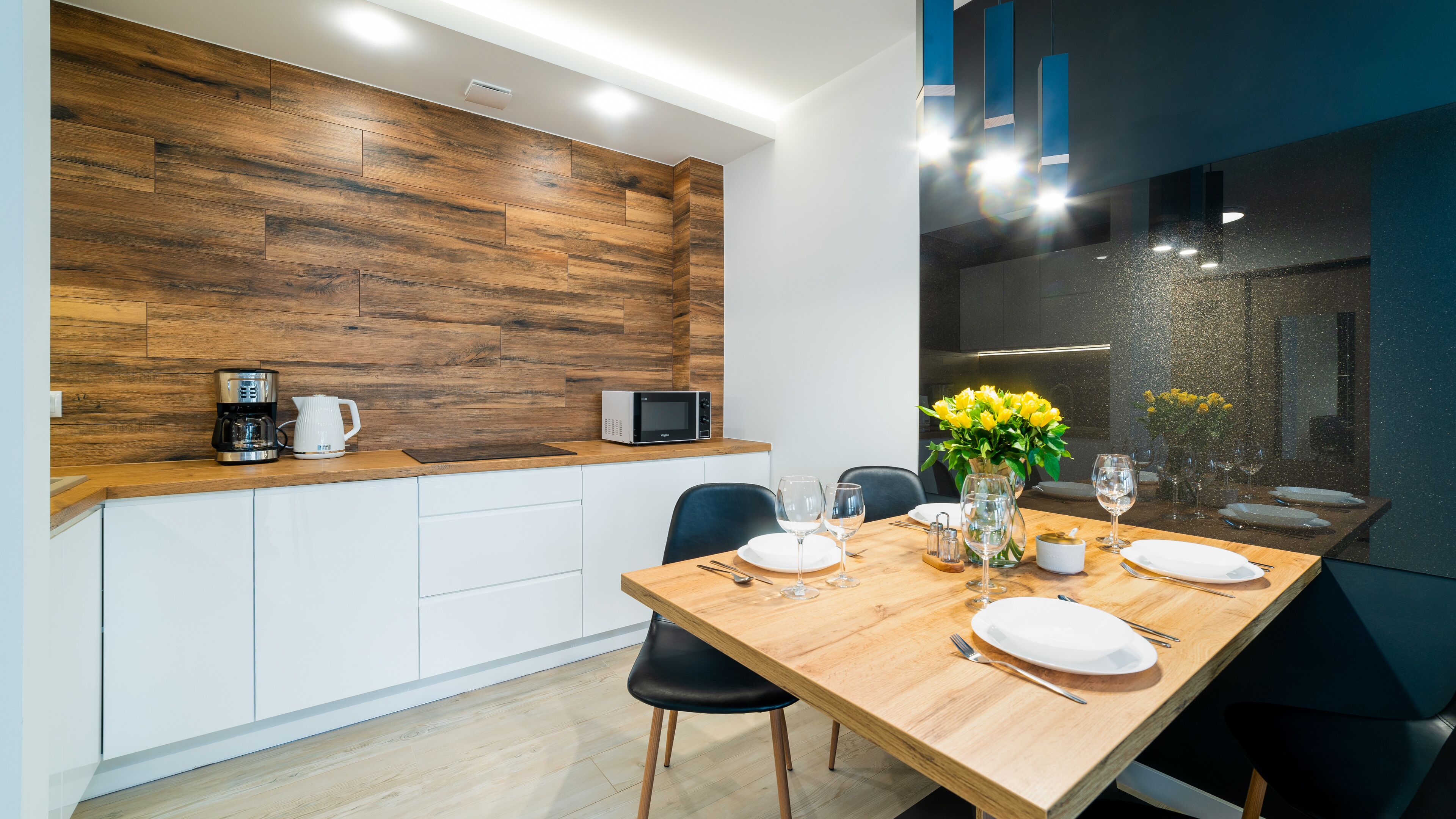 A modern kitchen with wooden cabinetry, a built-in microwave, and a coffee maker.