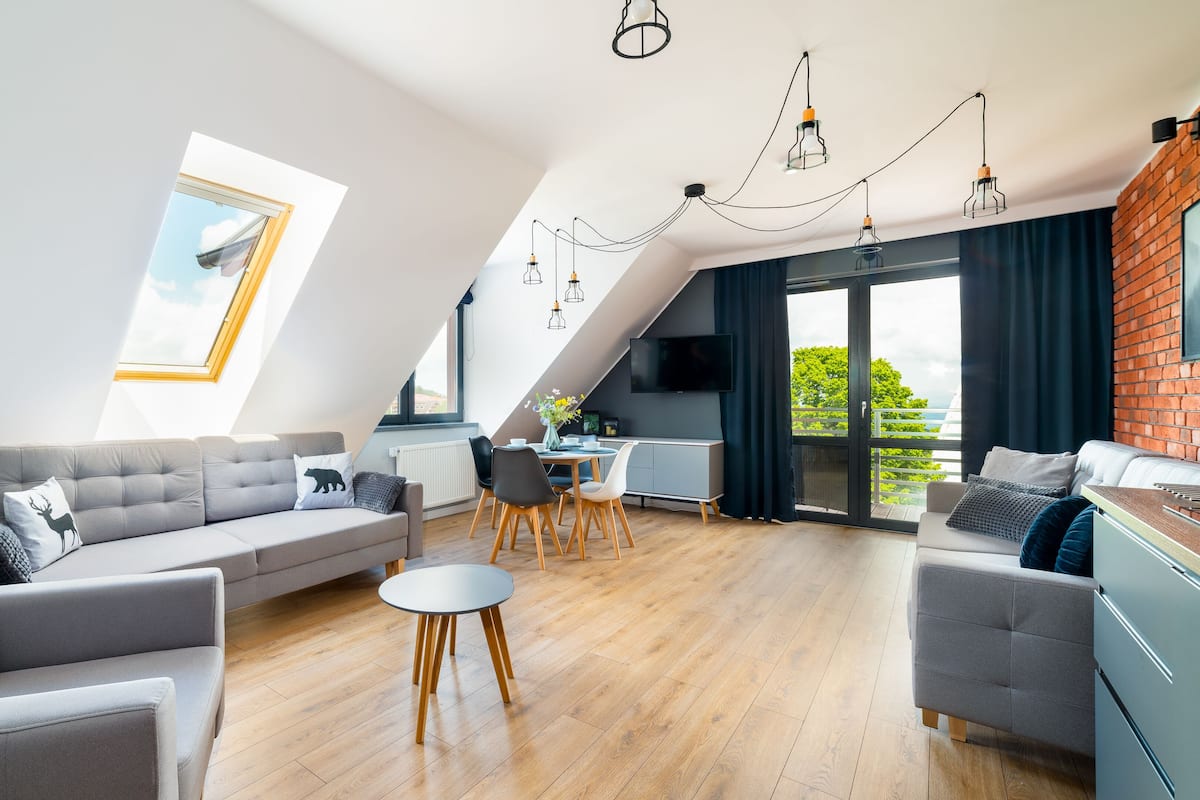 Un loft moderno con comedor, un conjunto de sofás y una cocina.