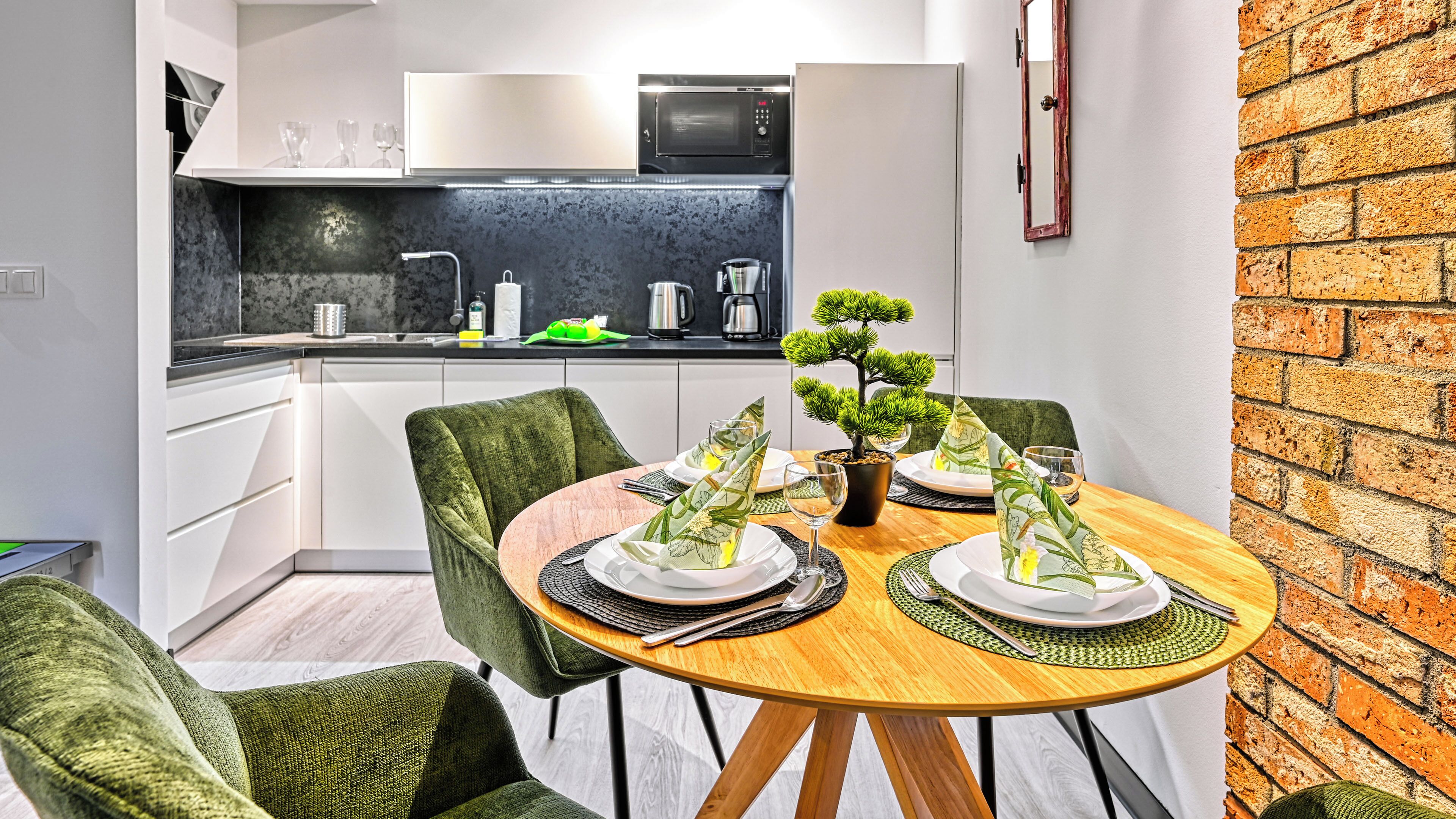 Une cuisine moderne équipée d’un four à micro-ondes, d’une machine à café et agrémentée d’une plante en pot.