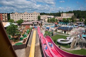 Enjoy water park fun with a thrilling red water slide and scenic surroundings.
