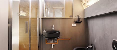 A modern bathroom with a glass shower enclosure, a black sink, and a bidet.