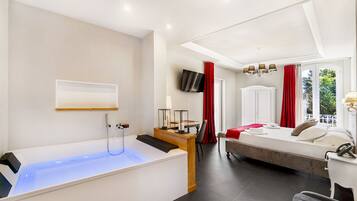 Una habitación de hotel moderna con bañera, cama, escritorio y televisor.