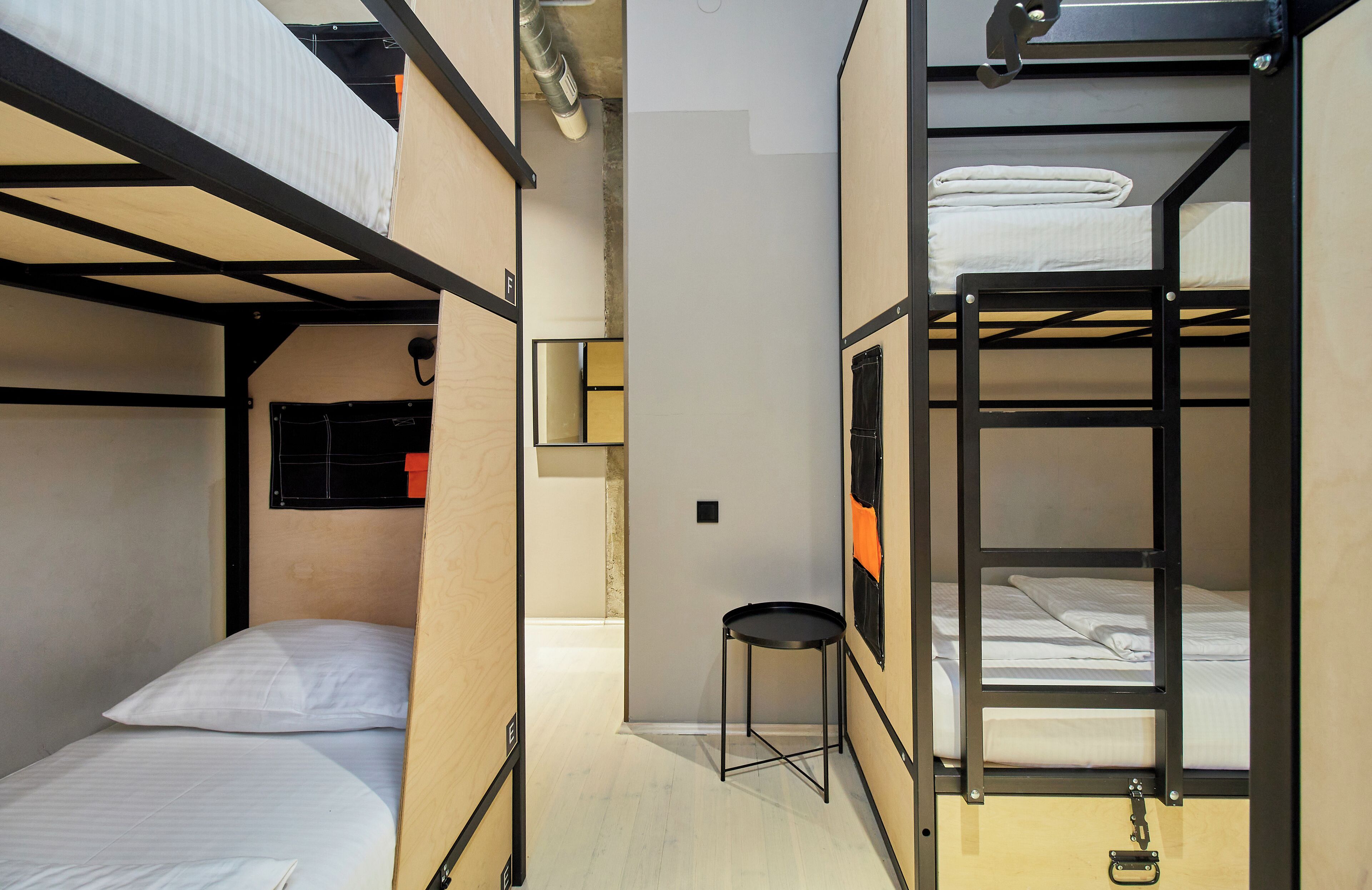Une chambre avec un lit superposé, une petite table et une fenêtre.