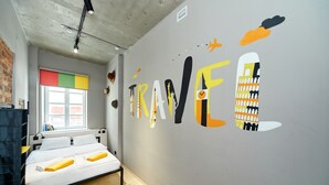 Una habitación con cama, ventana con vistas y una pared con arte abstracto.