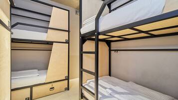 Camas literas con estructura de madera y ropa de cama blanca.