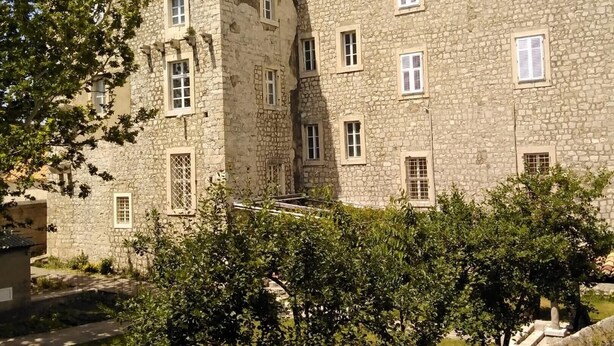A stone building with multiple windows and a courtyard. - Apartments Abjanic - Studio with Terrace - Ilije Sarake 8 (Dubrovnik)