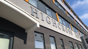 Ein modernes Gebäude, auf dem gut sichtbar der Schriftzug „HIGHCROFT HOTEL“ steht.