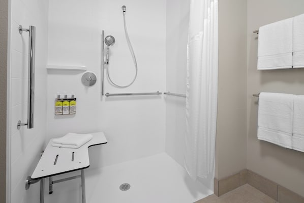 Uma casa de banho moderna com chuveiro, sanita e lavatório.