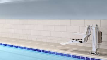 A swimming pool with a diving board and a lifeguard chair.