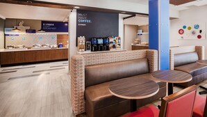 Un café moderne doté d’espaces pour s’asseoir, d’un comptoir où l’on prépare le café et d’une enseigne faisant la promotion du petit-déjeuner.