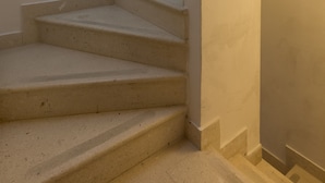 Um conjunto de degraus bege com uma parede curva à direita.