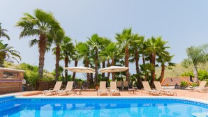 A swimming pool with lounge chairs and umbrellas, surrounded by palm trees. - Cubo's Mijas Finca Huerta Rica Bambu / shared pool / views (Mijas Pueblo)