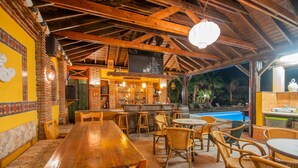 A restaurant with a wooden interior, outdoor seating, and a pool view. - Cubo's Mijas Finca Huerta Rica Bambu / shared pool / views (Mijas Pueblo)