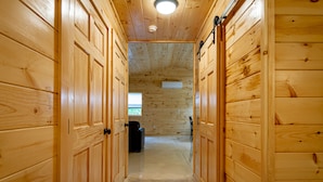 Un intérieur en bois avec un couloir menant à une pièce dotée d’une fenêtre.