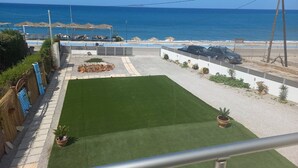 A patio with a view of the sea, a pool, and a car parked nearby. - Studio with sea view (Kokkinos Pirgos)