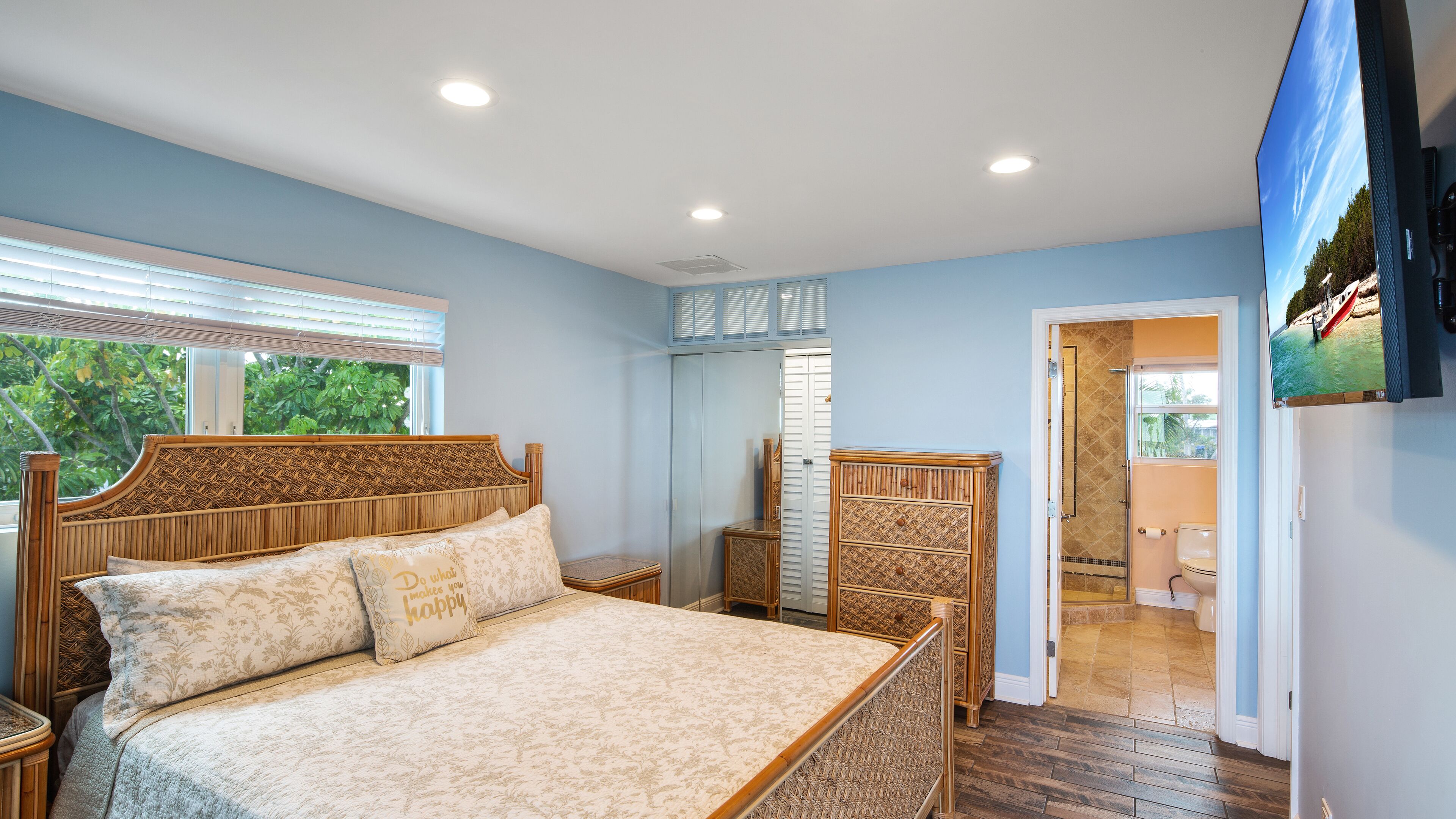 A bedroom with a bed, bedside tables, a wardrobe, and a television.