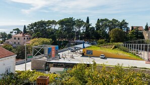 Un espace de stationnement doté d’une structure abritée, d’un arrêt de bus et offrant une vue sur la mer.