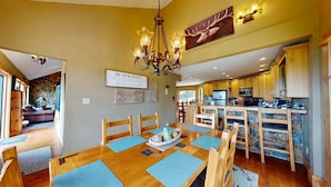 A cozy interior with a dining area, kitchen, and living space. - Views | WiFi | Fireplace | Elk Ridge Lodge (Angel Fire)
