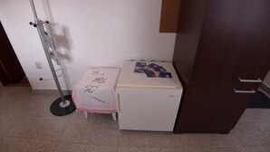 A small room with a white desk, a small refrigerator, and a broom leaning against the wall. - Apartment in Premantura with Garage near Kamenjak (Medulin)
