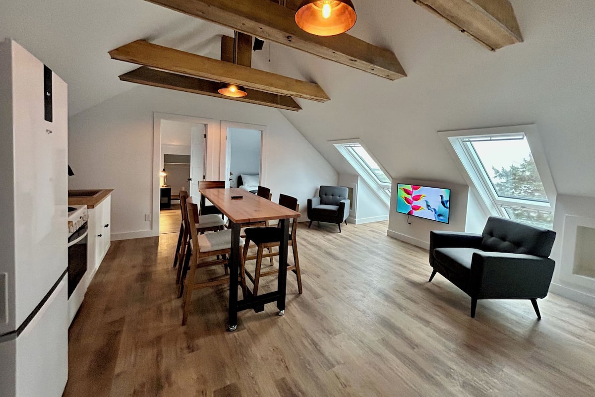 Un loft espacioso con comedor, sofá y televisor.