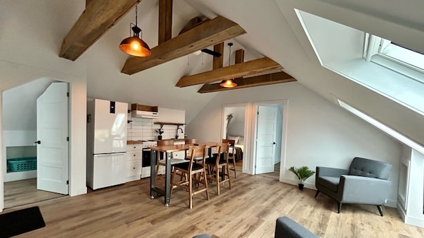 A spacious loft with a kitchen, dining area, and seating space. - Bleu Mer - hôtel & résidences (Carleton-sur-Mer)