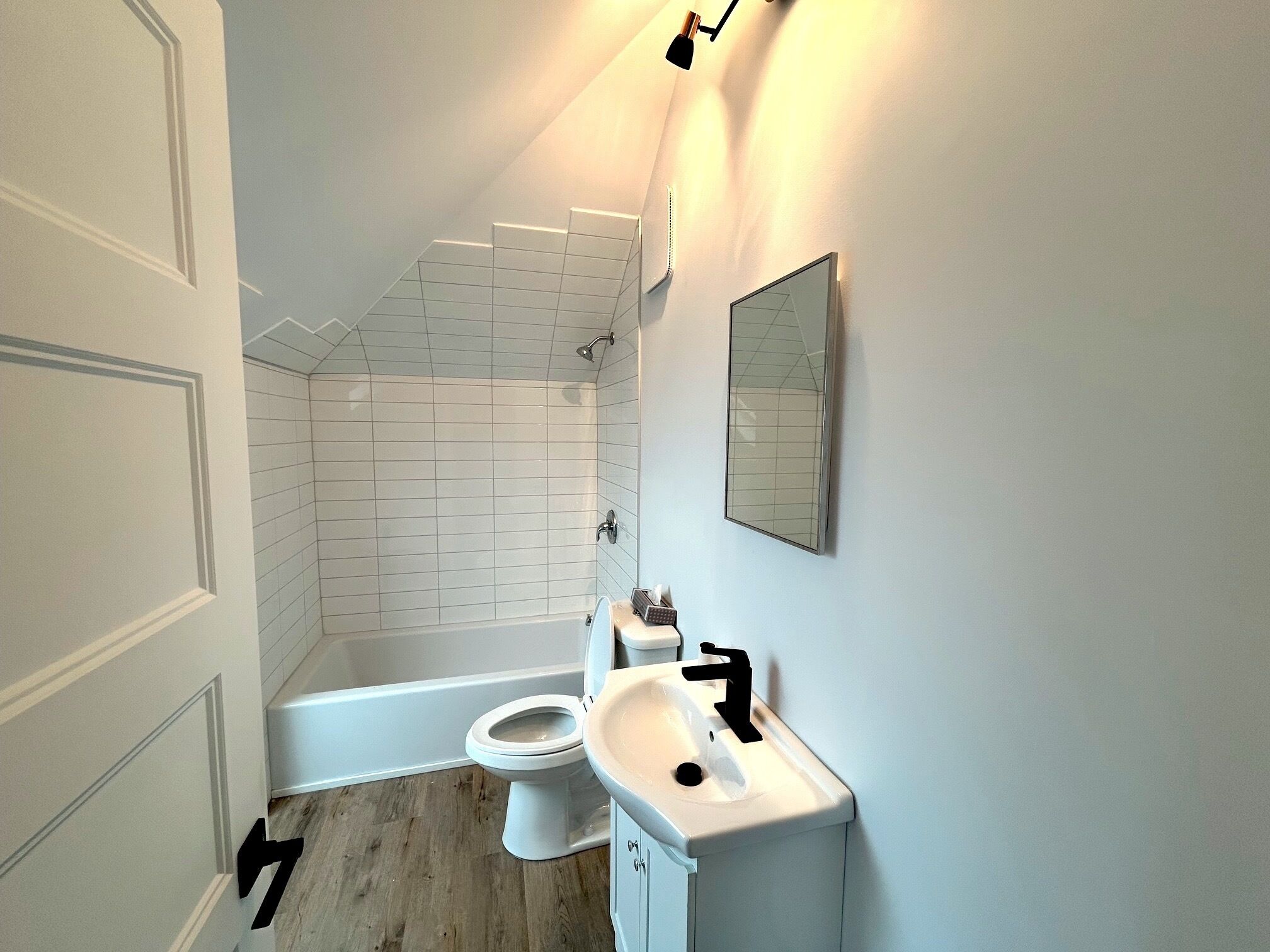 A bathroom with a toilet, sink, and shower.