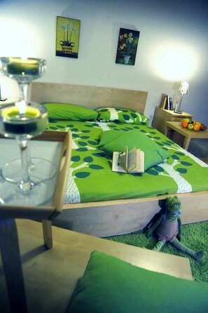 A neatly made bed with green bedding, a book, and a glass of wine on a tray. - Idealodge B&B (Colleferro)