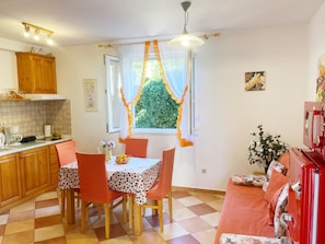 Une cuisine chaleureuse avec une table à manger, des chaises et un appareil électroménager rouge.