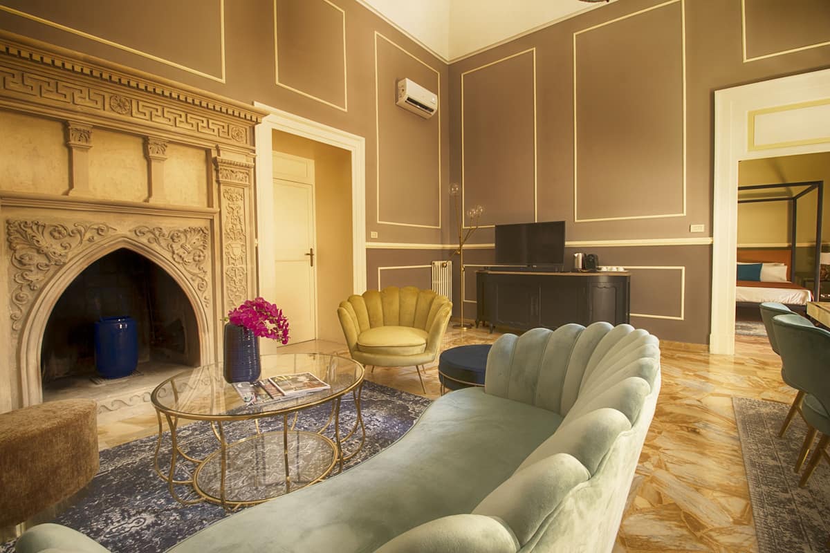 A spacious living room with a fireplace, comfortable seating, and a television.