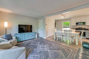 Ein modernes Wohnzimmer mit einer Couch, einem Fernseher und einem gemusterten Teppich.