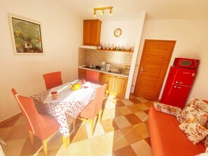 Enjoy meals in this kitchen with a dining area for two, a sofa, and a table.
